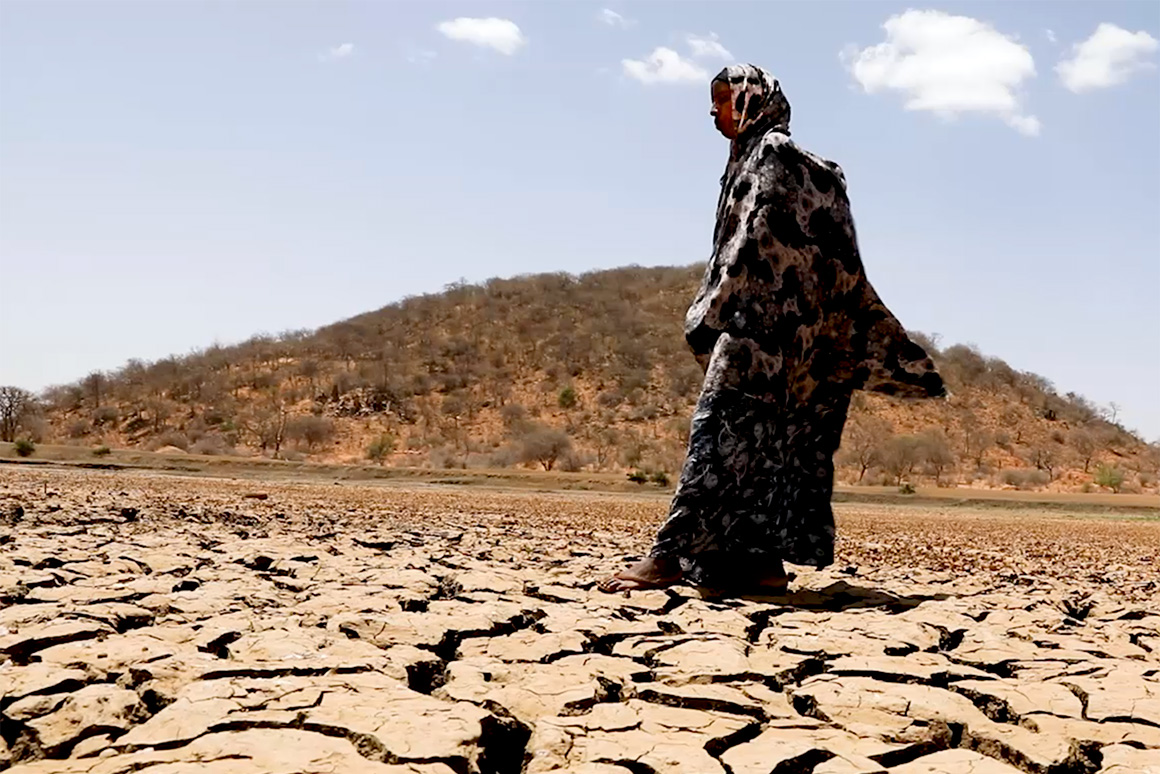 A person walking on dried earth.