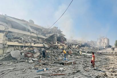 Palestinians standing outside a destroyed building. Photo: ©Shadow Pro for Mercy Corps.