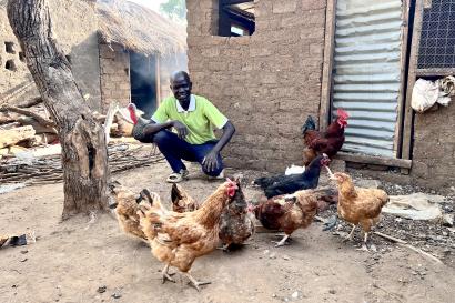 A person standing next to his poulry business chickens.