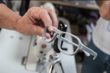 A hand holds a pair of glasses made on a 3d printer in zaatari refugee camp, jordan.