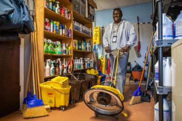 A person smiles while walking with a professional janitorial machine in grand bahama.