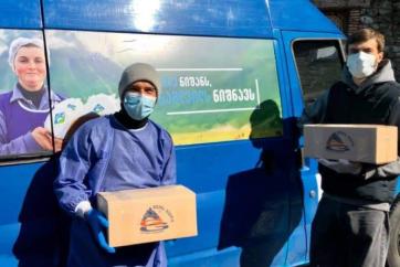 Man with box of provisions next to van