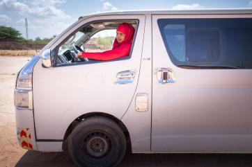 A person driving a van at a training center.