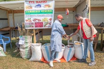 A vendor sells beans at a fair.