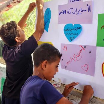 Young people hanging art projects.