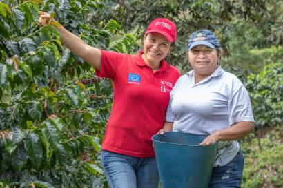 Two people standing together in an orchard.