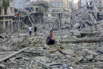 Residents walk through the rubble of the al-remal neighborhood in gaza city after it was destroyed by air raids.