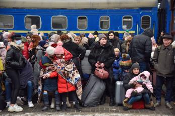 People gather to board trains as they flee ukraine.