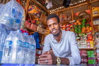 A young man stands at his shop in ethiopia.