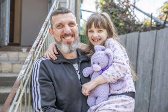 A man poses with his daughter in ukraine