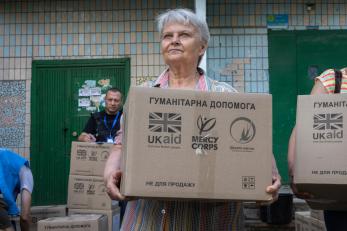A woman carries an aid box in ukraine