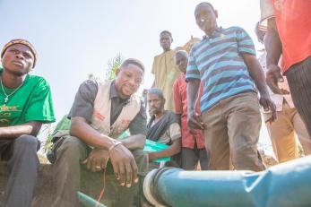 A mercy corps team member sets up a solar-powered water pump in nigeria