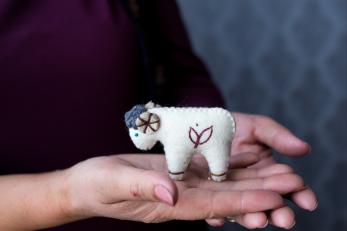 Set of hands holding a felted ram