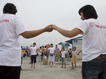 Two mercy corps team members holding hands