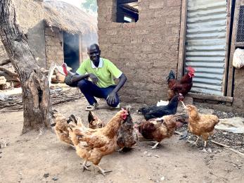 A person standing next to his poulry business chickens.