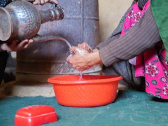 Washing hands in a basin.